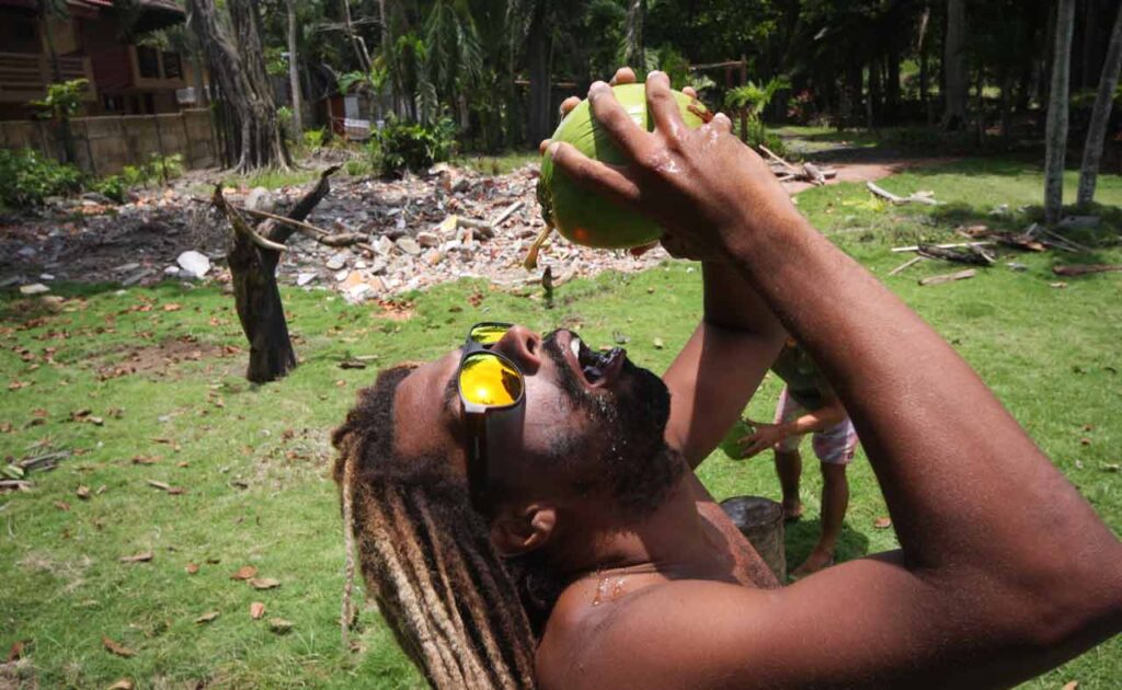 Bomber equipo surfista bebiendo coco agua con Bomber gafas de sol