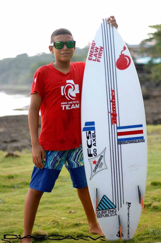 Bomber Floating Eyewear Latin America Equipo con gafas de sol mientras posa con su tabla de surf en Hermosa Costa Rica