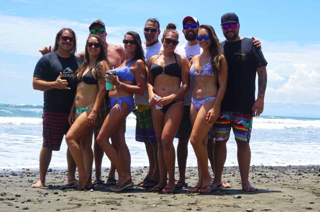 Amigos agrupados en la playa en Costa Rica vistiendo bombardero gafas de sol flotantes polarizadas